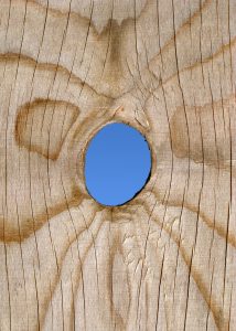 A peep hole in a fence